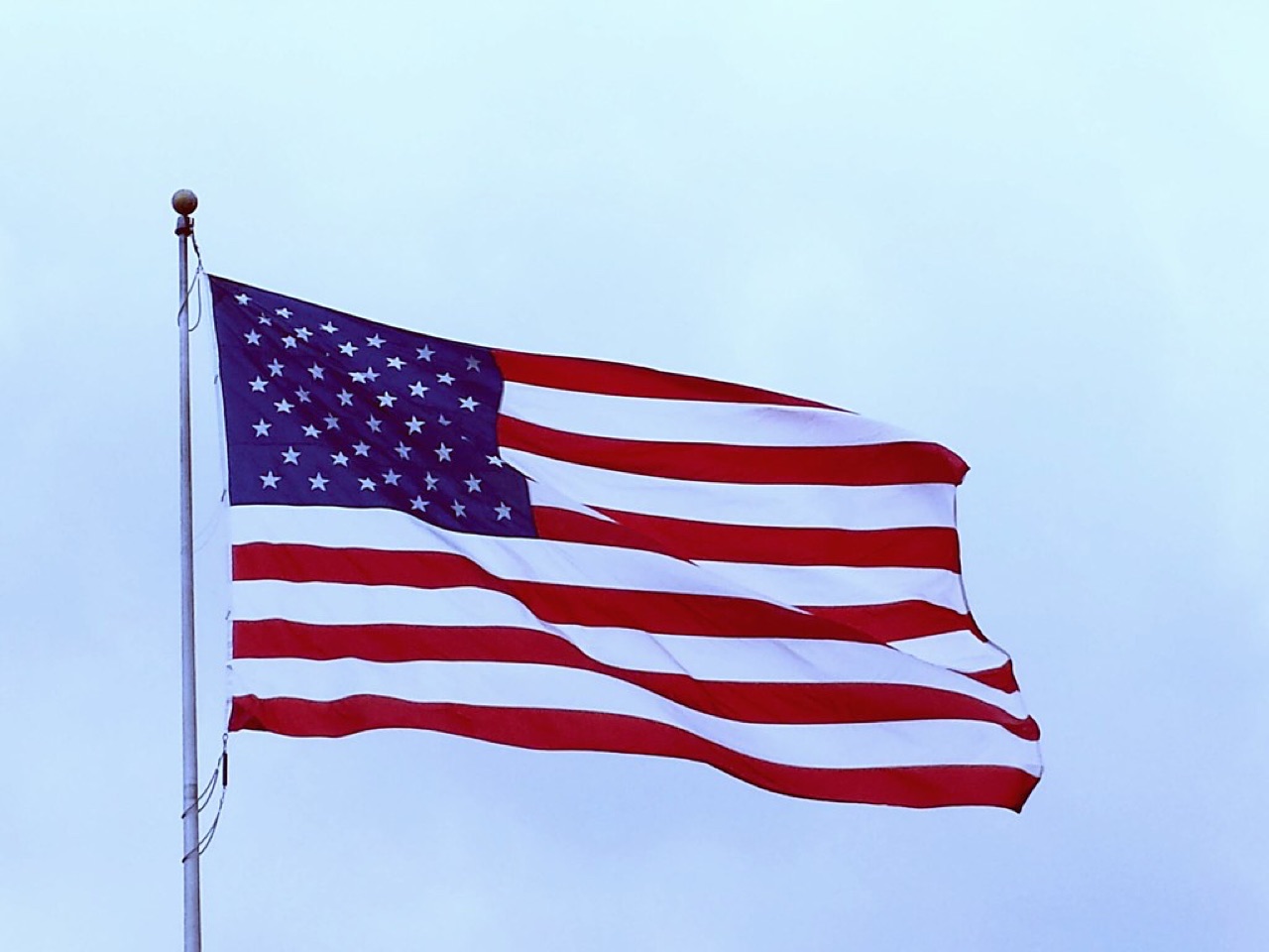 An American flag waving against a blue sky.