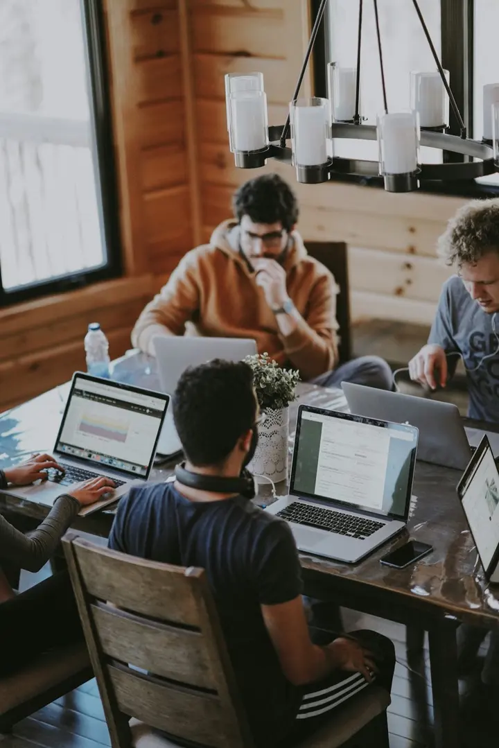 A small team working together at laptops around one table